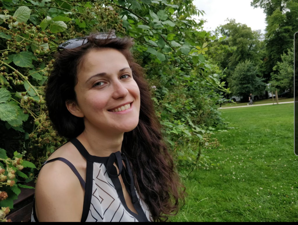 A picture of Alex smiling in the garden.