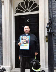 Stuart stood in front of number 10 Downing Street with his Guide Dog
