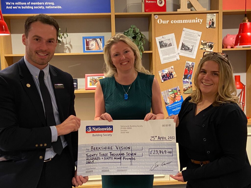 Laura holding a big cheque with staff from Nationwide Building Society