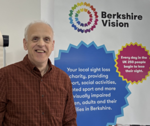 A photo of kevin next to a Berkshire Vision graphic stand