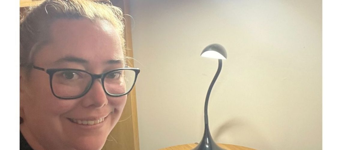 Justine uses a specialist light to read a magazine