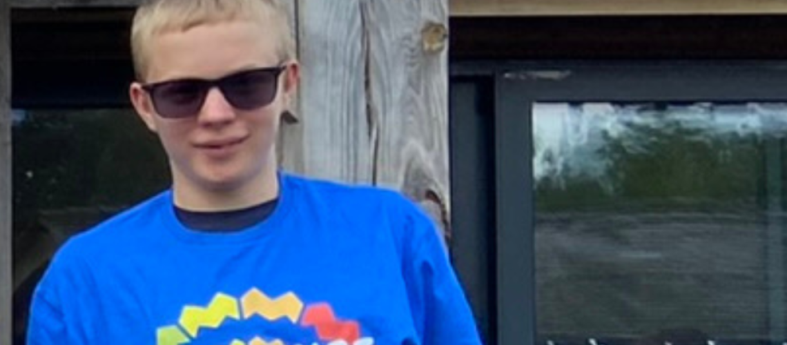 Tom is wearing dark glasses and a blue Berkshire Vision residential tshirt- he has short blonde hair