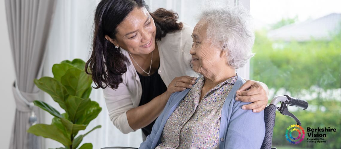 A photo of an older lady in a wheelchair being talked to kindly by a younger person