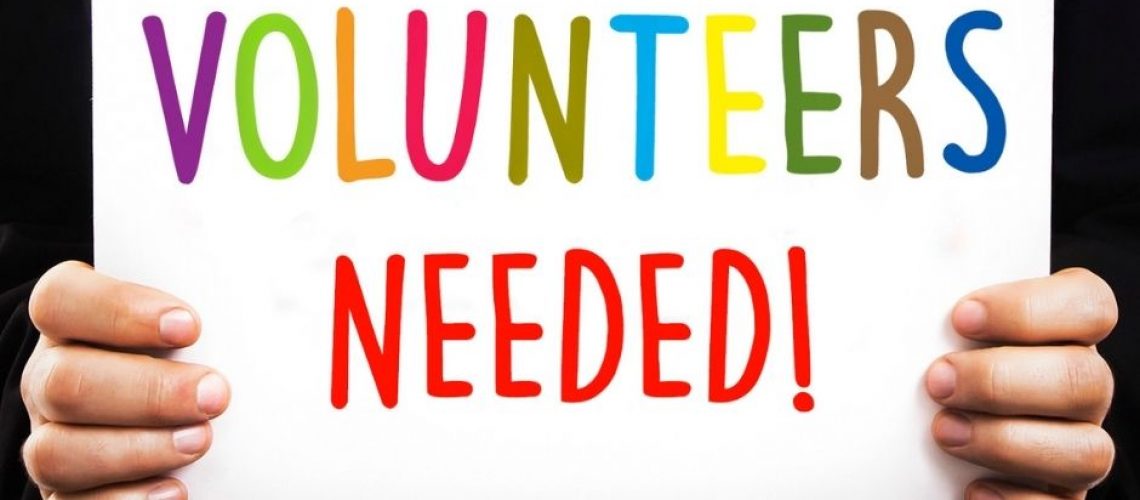 Brightly coloured writing says "Volunteers Needed!"